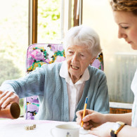 oudere vrouw en verzorgende doen een spel