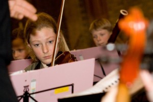 jonge violiste tijdens uitvoering jeugdorkest